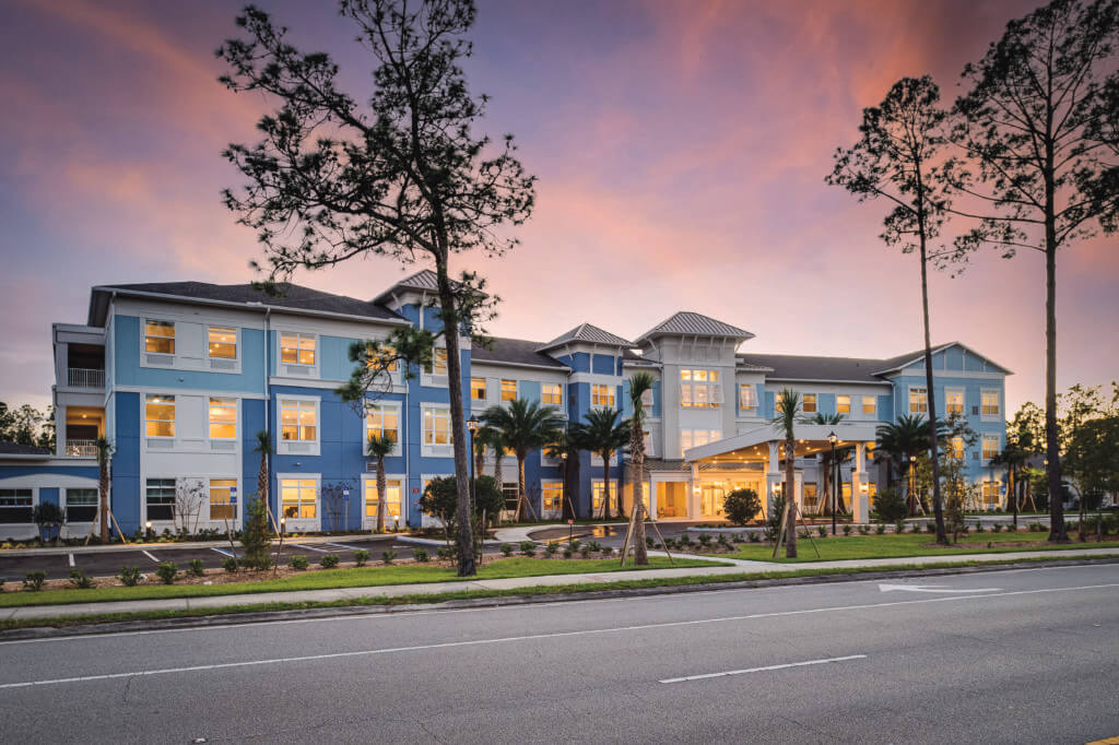 Exterior View of the Palm Coast Senior Living Center with a beautiful purple sunset.