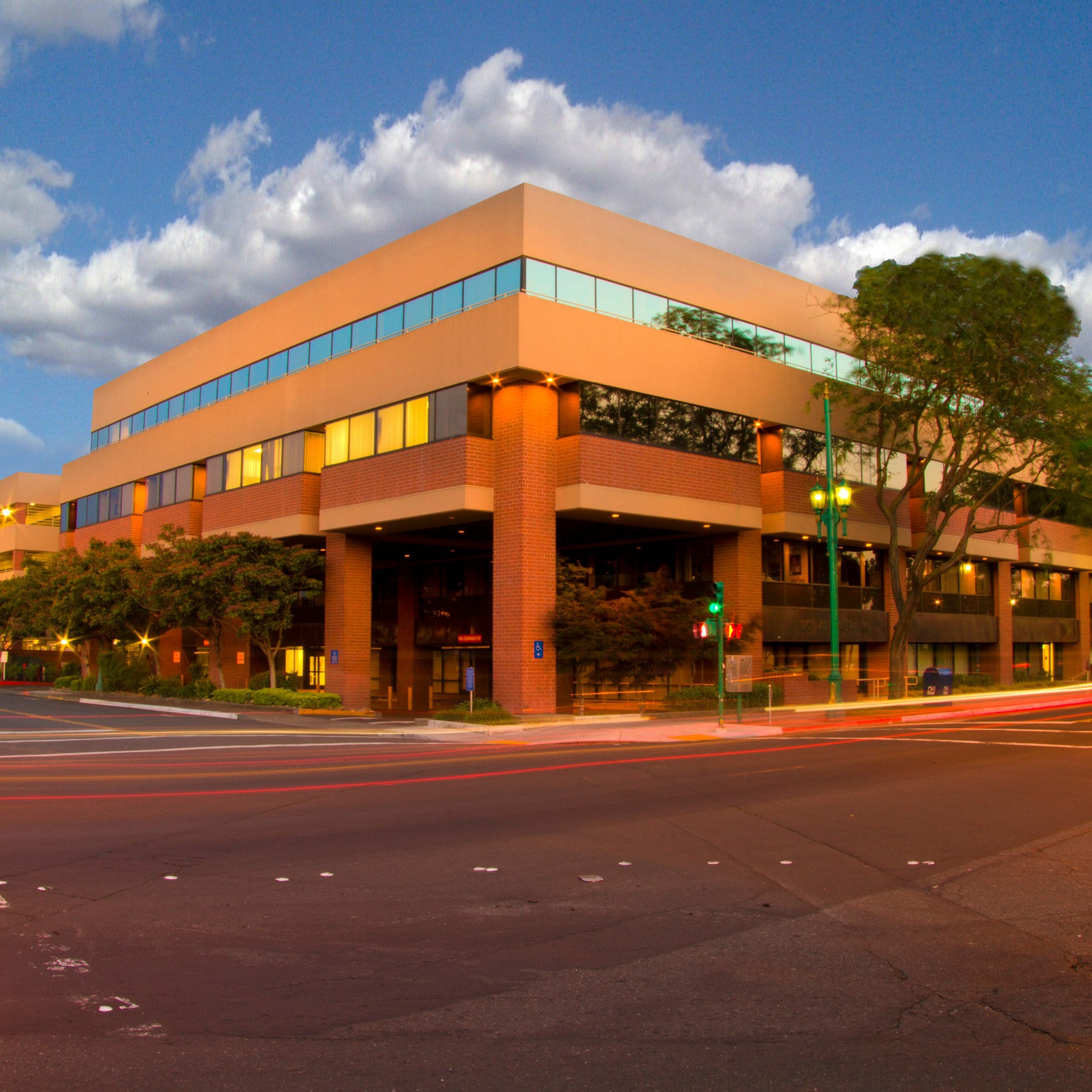 Exterior street view of Alhambra Medical Office with brick and glass finishes with trees and streetlights lights outside