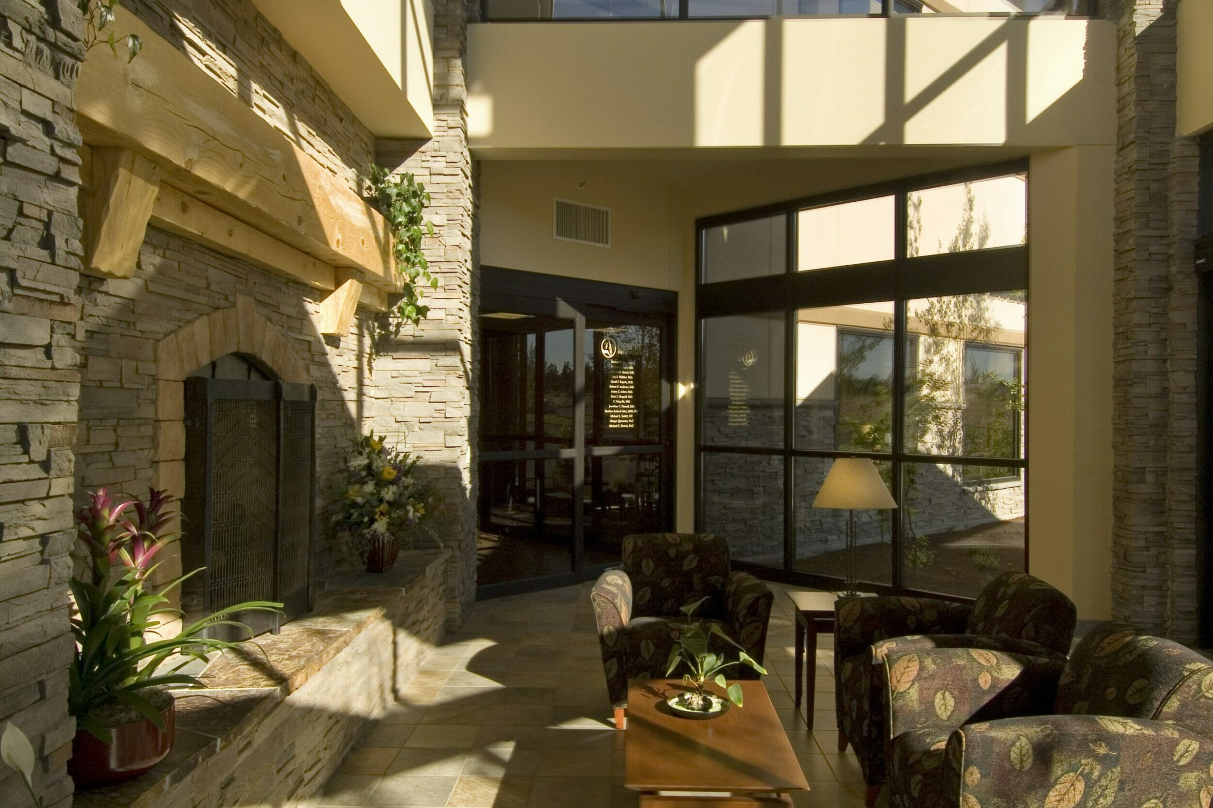Two-story stone fireplace and seating area inside Bend Surgery Center