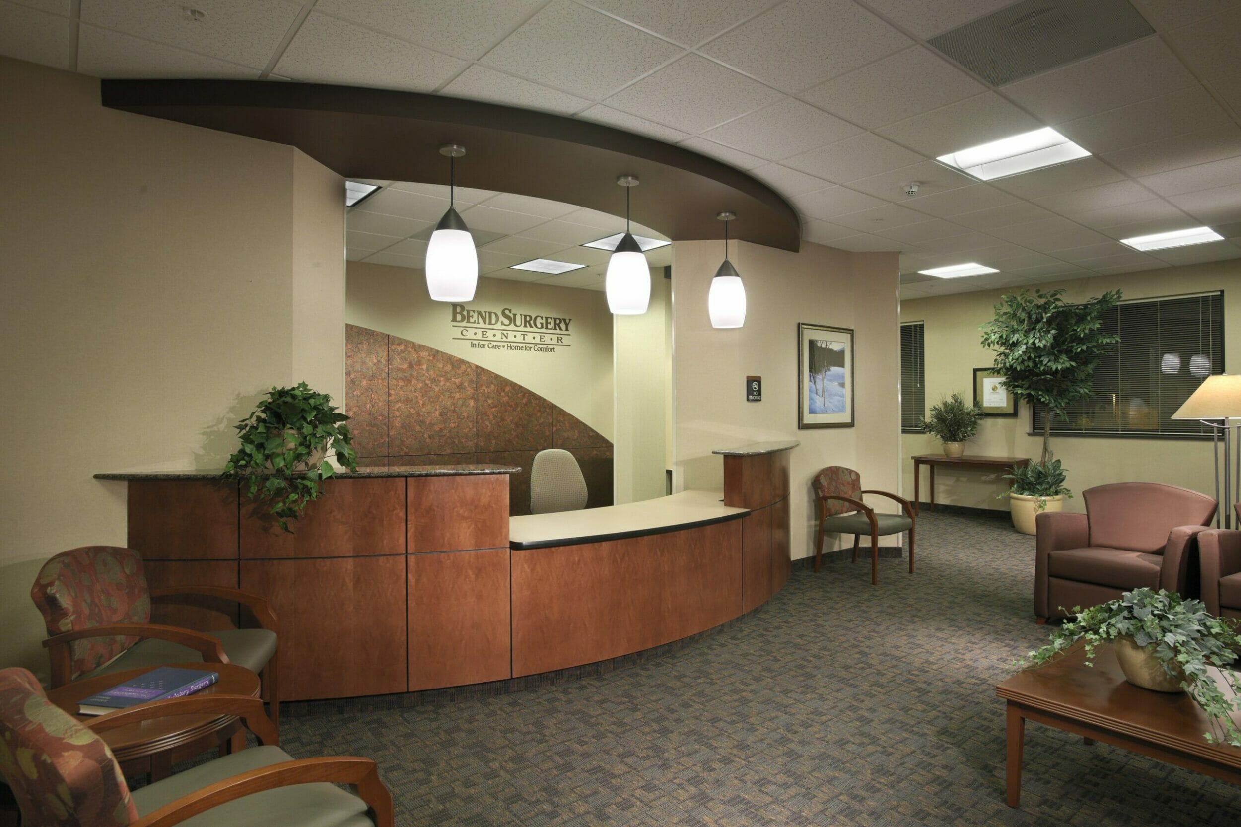 Front desk and lobby inside Bend Surgery Center, with multiple chairs and plants