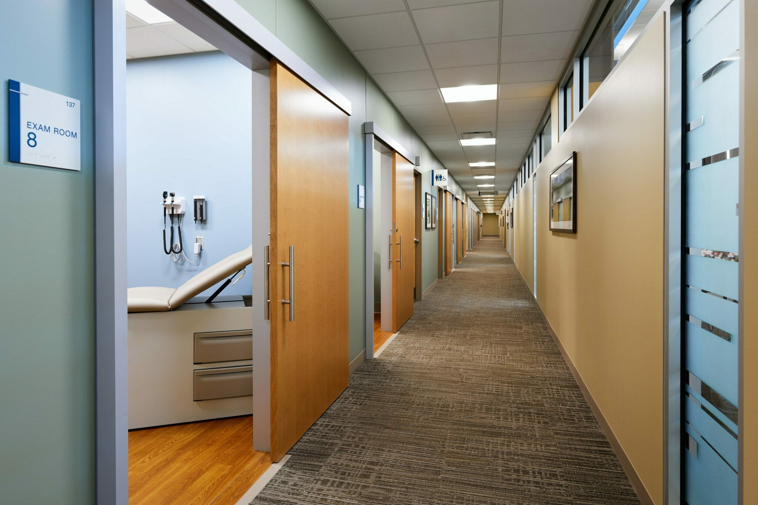Exam room corridor medical office building, wood sliding doors
