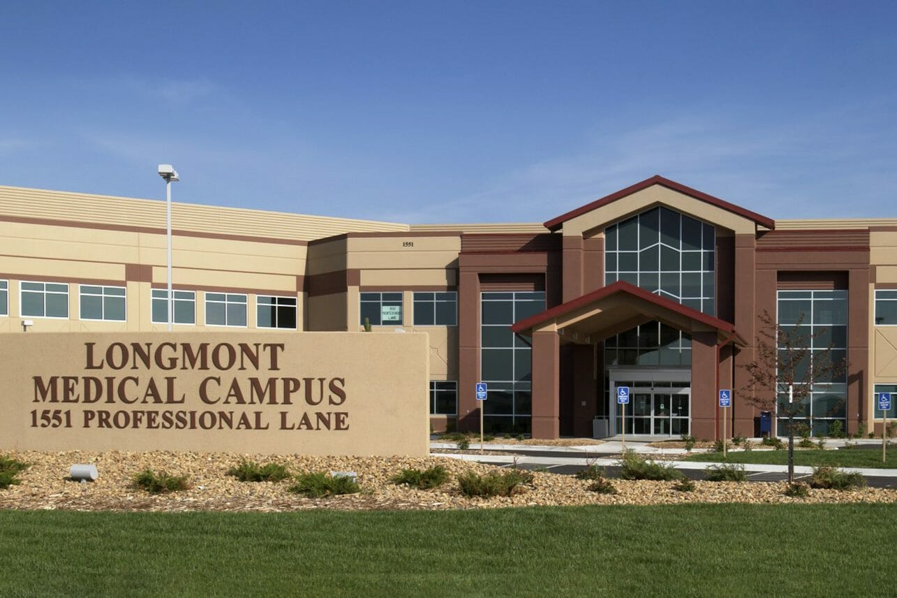 Exterior view medical office building, main entrance, Longmont medical campus sign, tan and brown building and sign