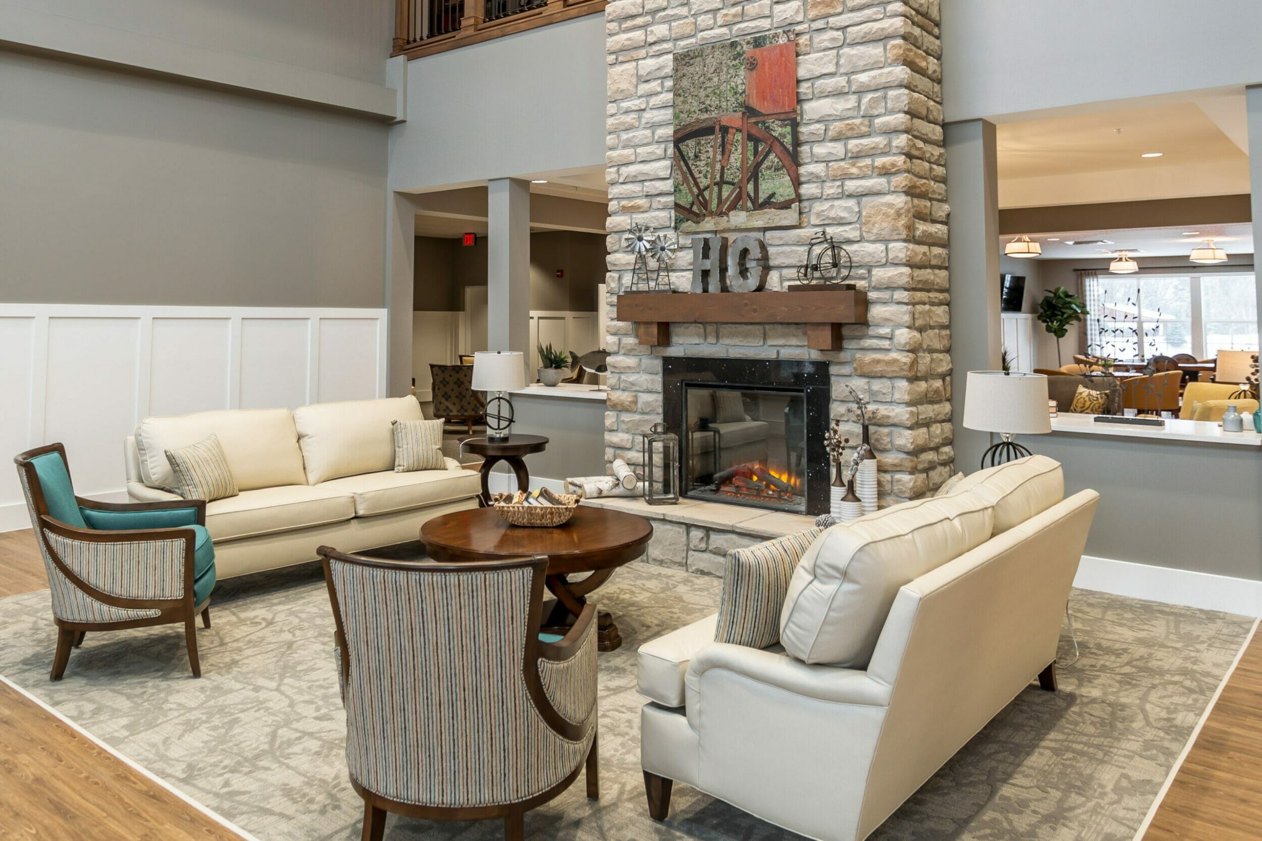 two-story duo stone fireplace in living room area couches and chairs around the fire