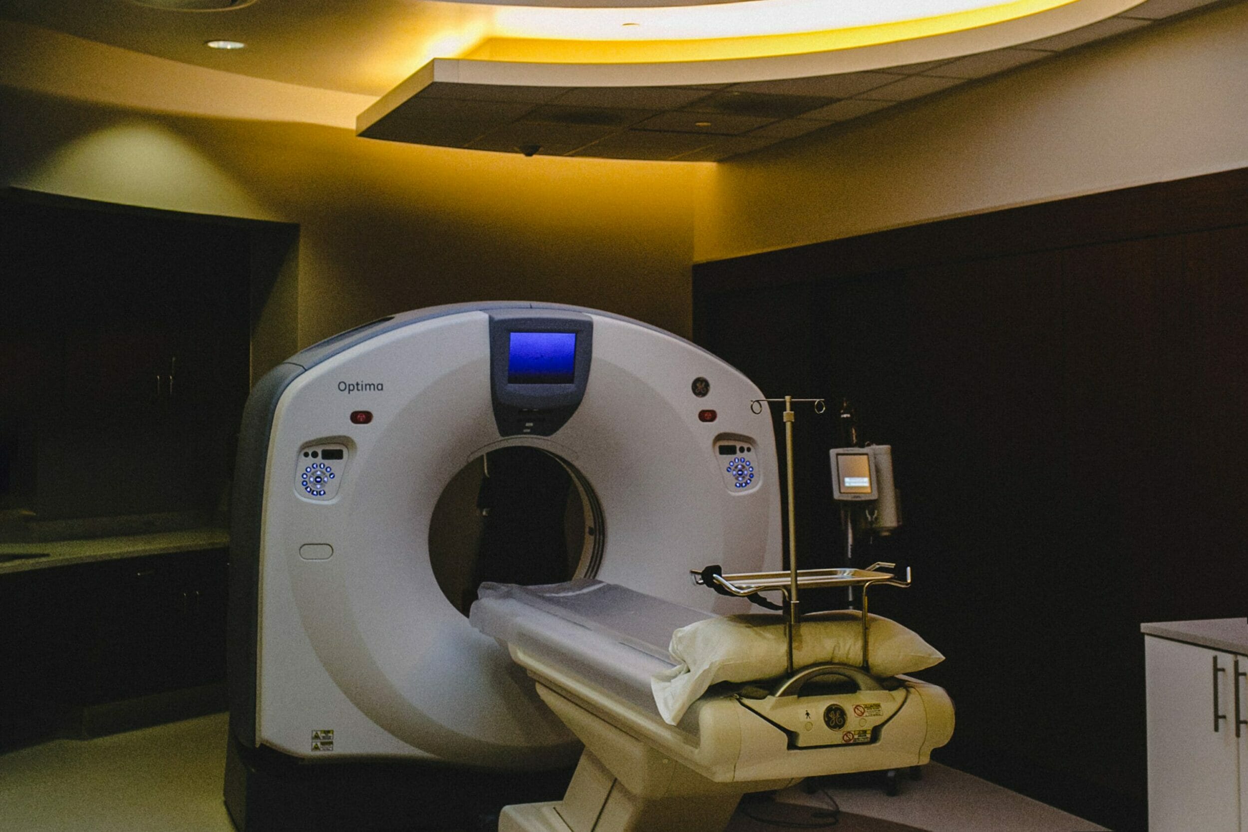 GE Optima CT Scan machine in dark room with fake sky and tree ceiling