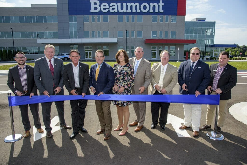 NexCore members pose in front of a ribbon for the opening of Beaumont Health